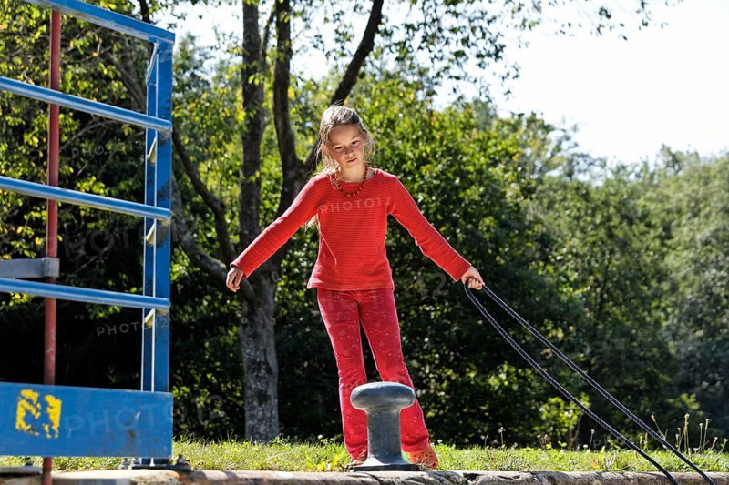 Girl fastening a rope to secure the boat in the lock chamber