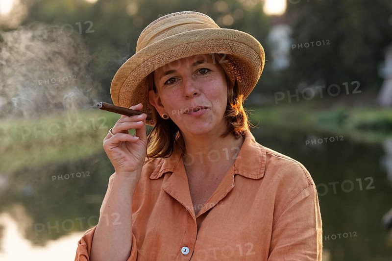Woman smoking a cigar on a houseboat on the Canal des Vosges