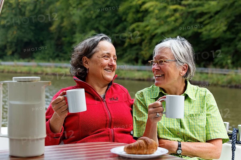 Two holidaymakers having breakfast at the rear terrace of a Penichette