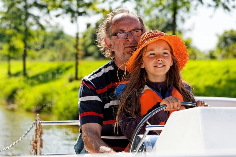 Father and daughter at the wheel of a Penichette