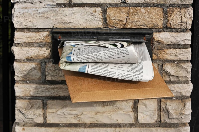 Full letter box of a house in a wall
