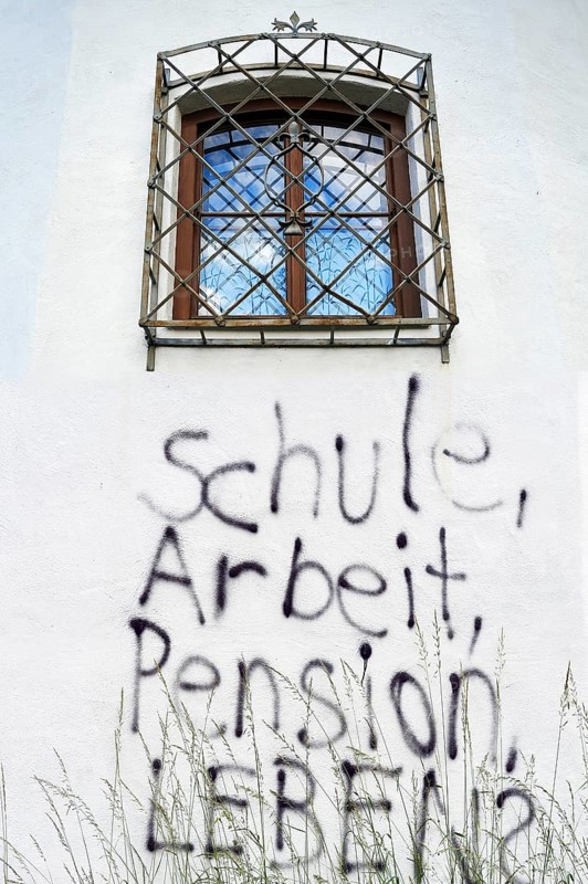 Graffiti under a barred window of a castle wall 'Schule