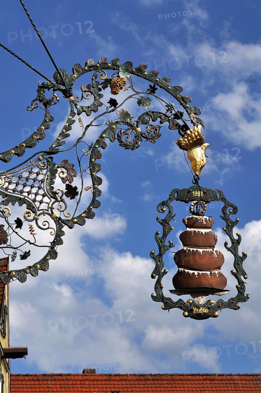 Hanging sign with a 'Baumkuchen' or tree cake from the Kaffeehaus Trexler coffee house