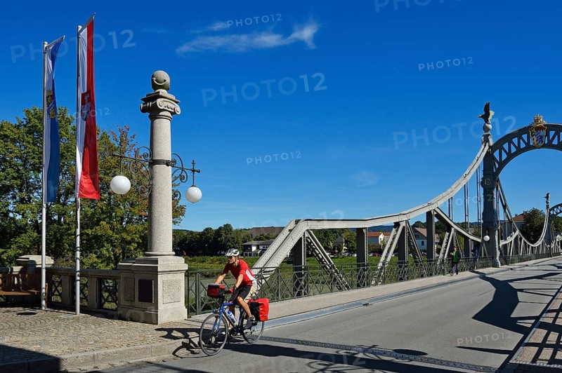 Cyclist crossing Laenderbruecke bridge between Bavaria and Salzburger Land