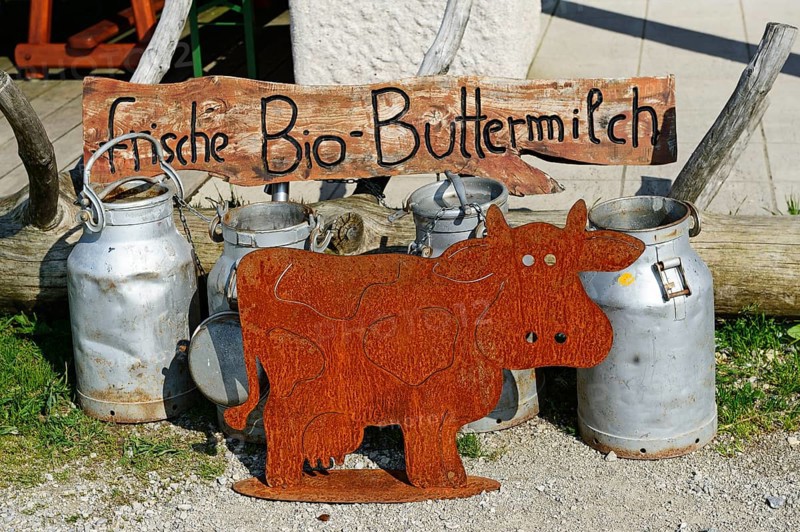 Milk cans in front of the Sonnenalm with a sign 'frische Bio-Buttermilch'