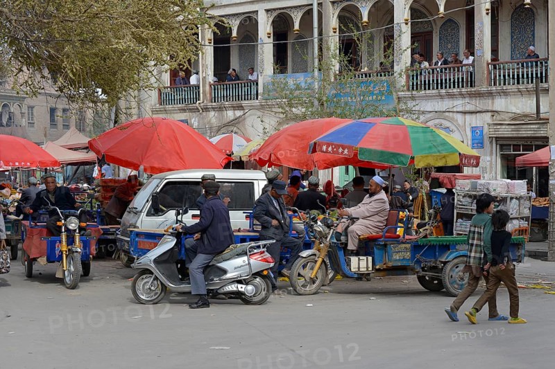 Market stalls with Muslim traders and a tea room on the porch of a mudbrick house