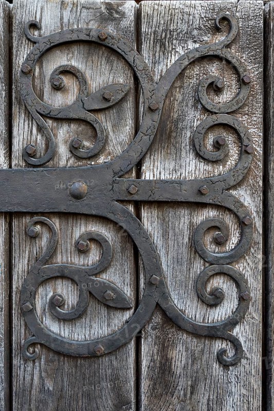 Hand-forged iron works on a wooden door