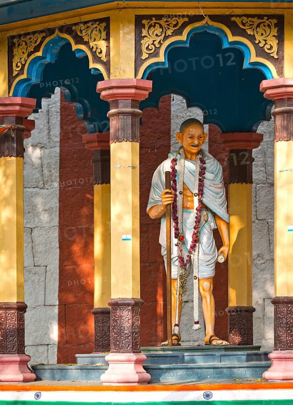 Representation of Mahatma Gandhi with walking stick in a small pavilion on the temple wall