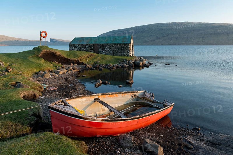 Red boat in front of a boat house on Lake Sorvagsvatn or Leitisvatn