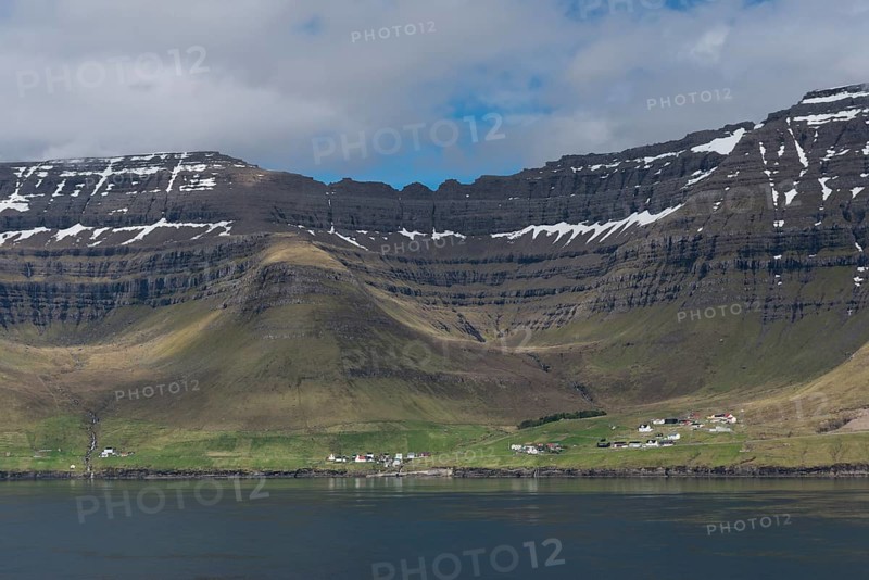 Kunoy village by the sea in front of steep mountains