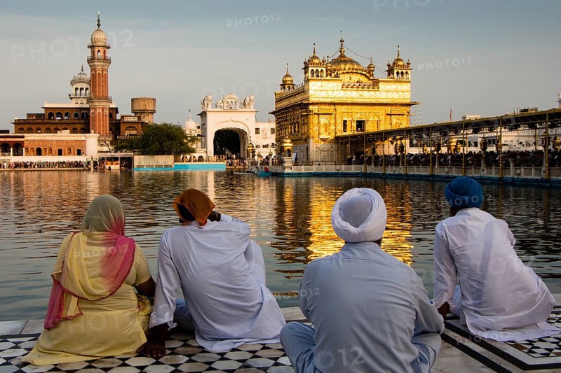 Sikh pilgrims sitting in front of the Harmandir Sahib or Golden Temple