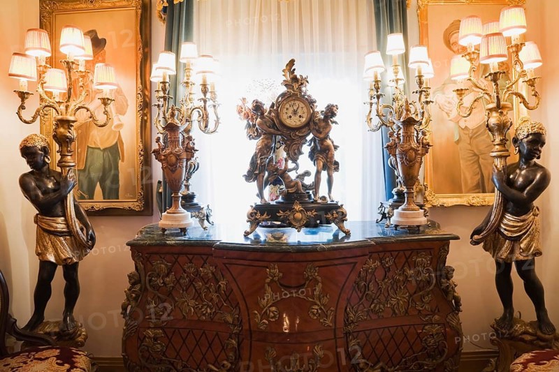 Antique dresser and furnishings adorn a hallway inside a Victorian mansion