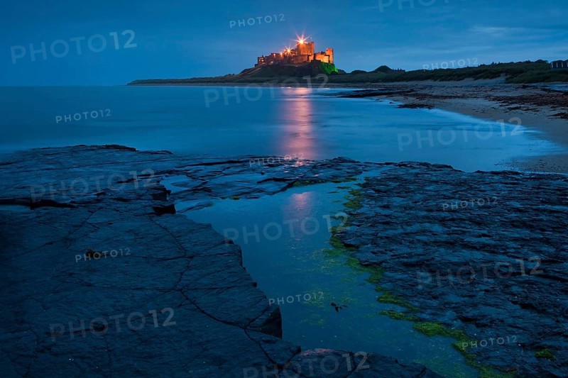 Bamburgh Castle illuminated at dusk