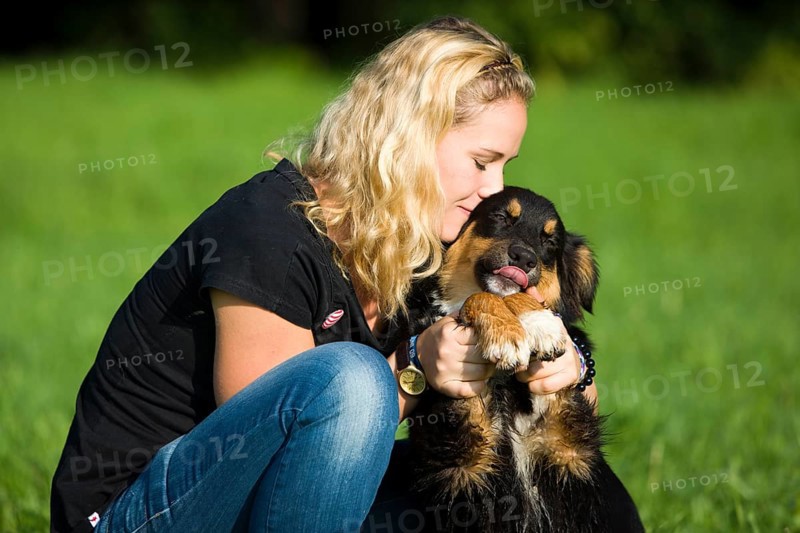 Young woman cuddling an Australian Shepherd dog
