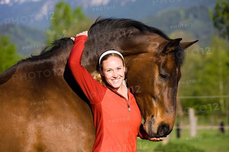 Young woman embracing an Austrian Warmblood