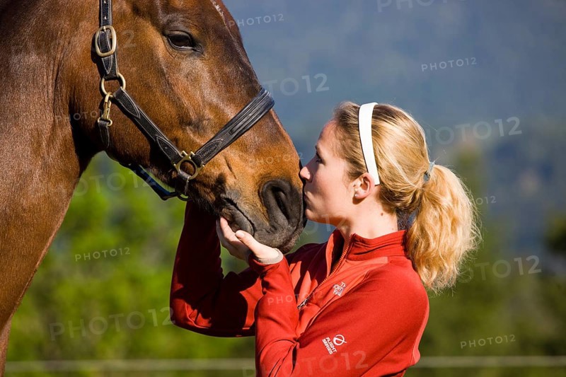 Young woman cuddling an Austrian Warmblood