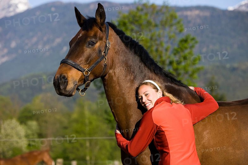 Young woman embracing an Austrian Warmblood