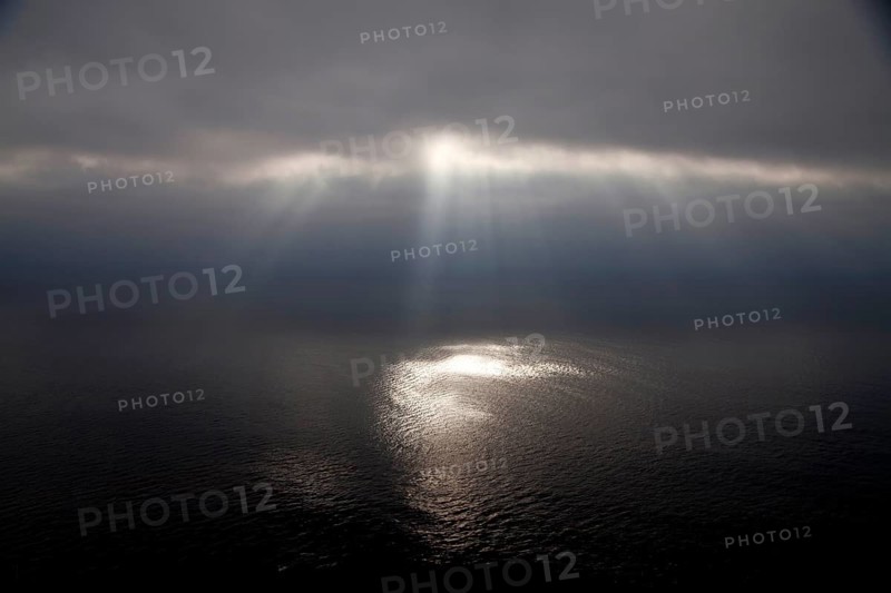 Dark clouds and sun rays over the Pacific Ocean