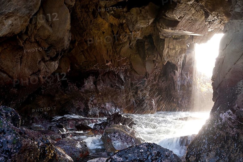Surf and a ray of light on the rocky coast of Pfeiffer Beach