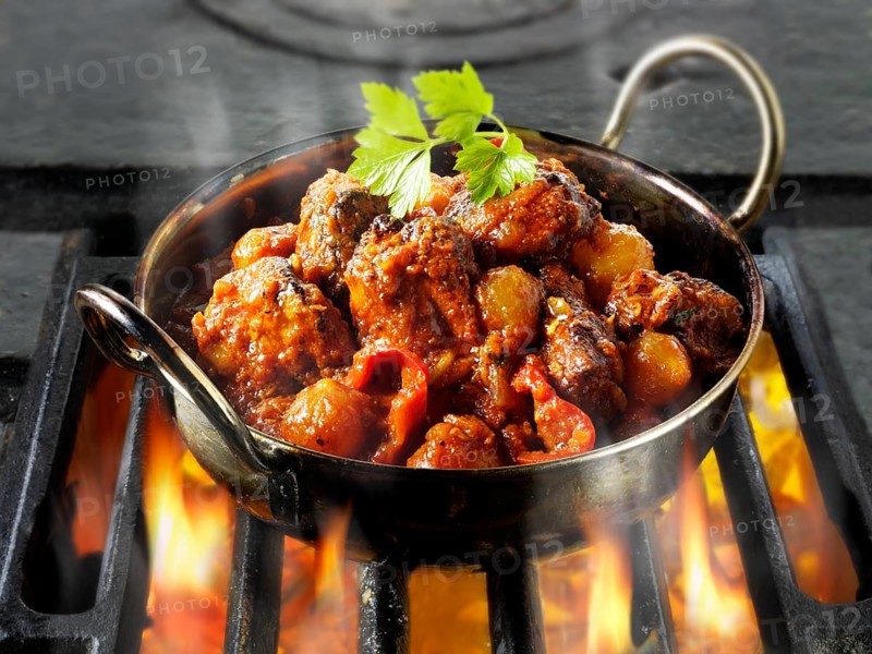 Indian Piri Piri chicken curry being cooked over hot charcoals