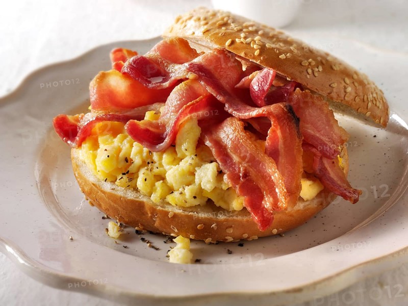 Crispy streaky bacon and scrambled eggs on a bagel