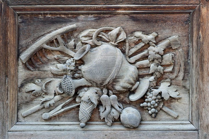Carved relief image with agricultural motifs on the wooden portal