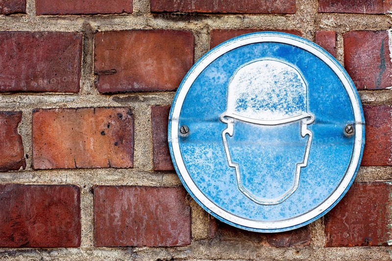 A faded sign at a construction site to wear a hard hat