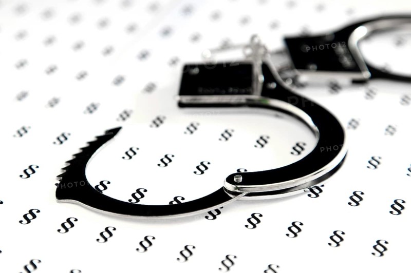 Handcuffs lying on German legal symbols