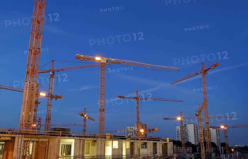 Construction cranes on the construction site of the Milaneo at dusk