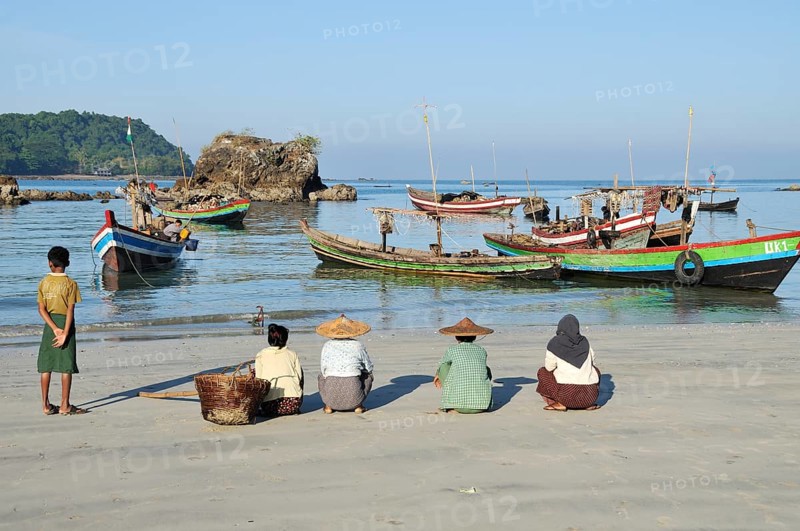 A fisherman's family is waiting on the beach for the return of the boats