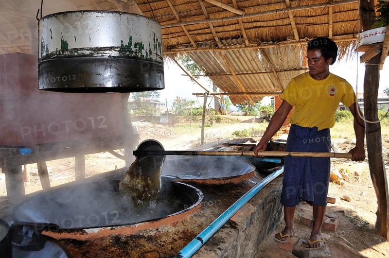 Man pouring sugar juice from one vessel to another