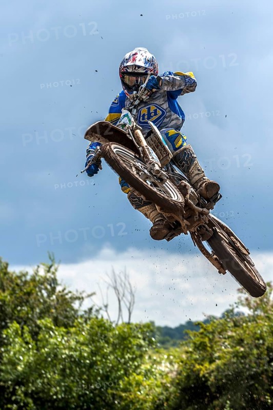 Biker on a motobike jumping at a motocross event