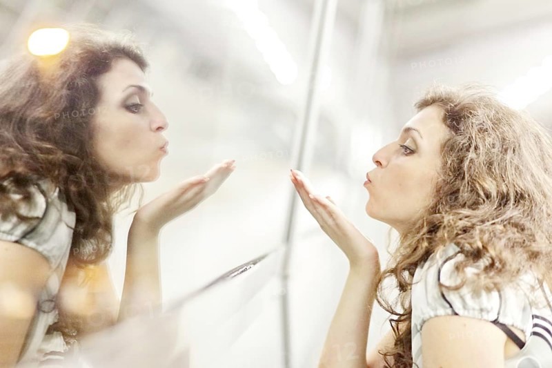 Woman blowing a kiss to her mirror image