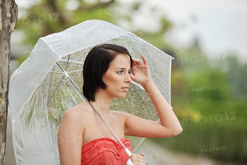 Woman with umbrella outside in a summer rain