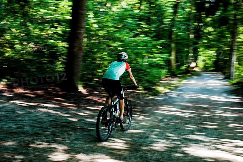Woman riding a mountain bike along the Forstweg trail in Feldafinger Park