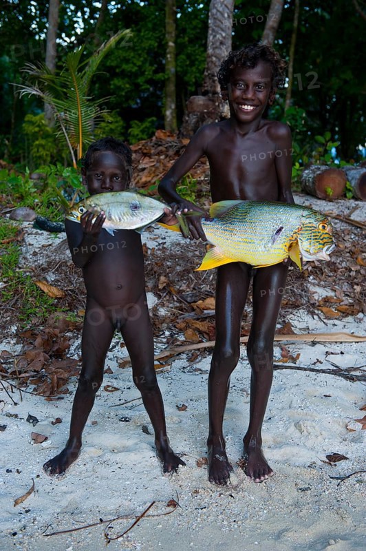 Boys proudly showing the fish they caught