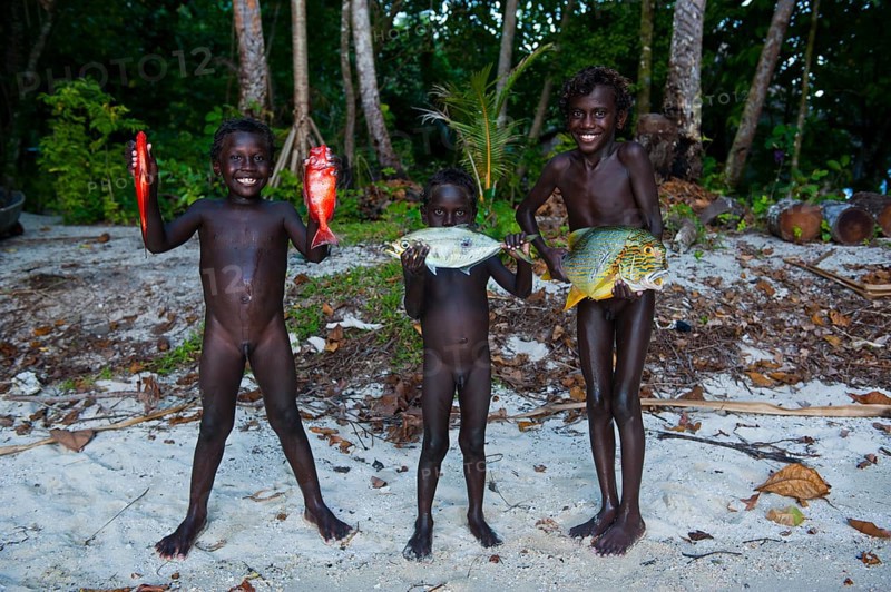 Boys proudly showing the fish they caught