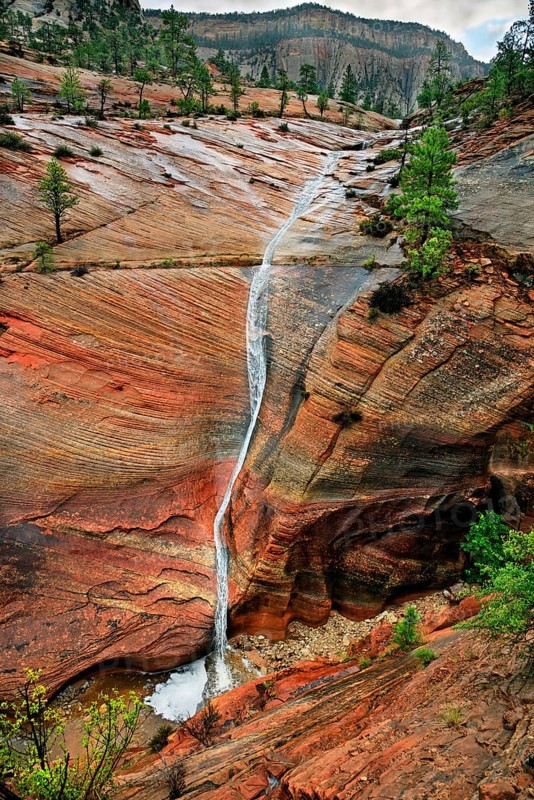 Water draining off over red Navajo sandstone rocks after a rainstorm near Canyon Overlook