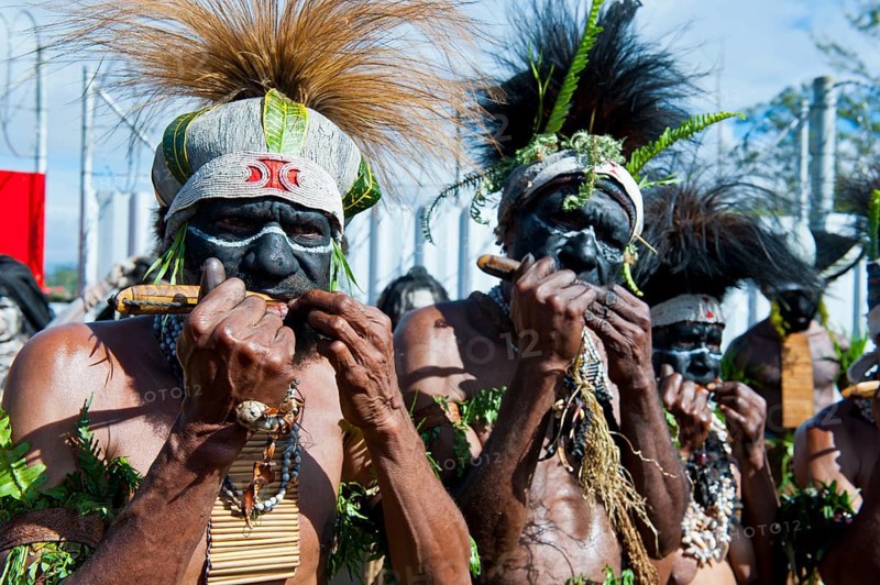 Members of a tribe in colourfully decorated costumes with face paint at the traditional sing-sing gathering