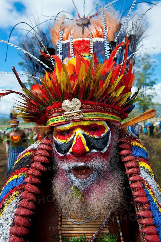 Man in a colourfully decorated costume with face paint at the traditional sing-sing gathering