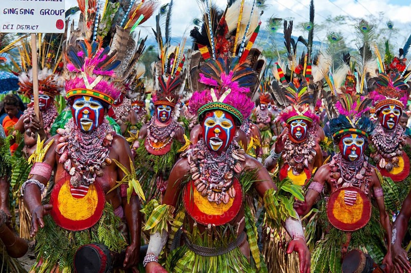 Members of a tribe in colourfully decorated costumes with face paint at the traditional sing-sing gathering