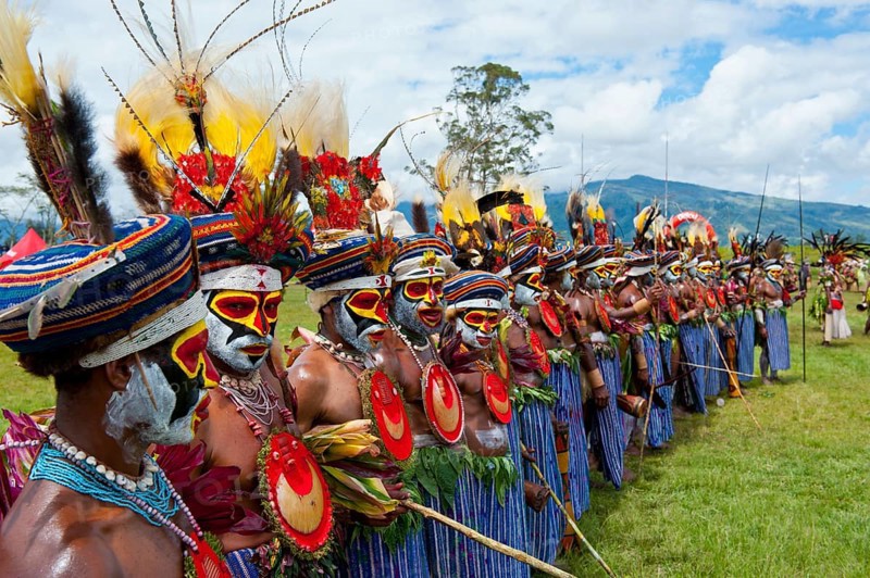 Members of a tribe in colourfully decorated costumes with face paint at the traditional sing-sing gathering