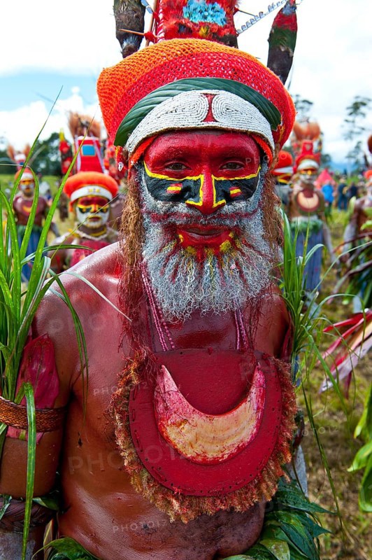 Man in a colourfully decorated costume with face paint at the traditional sing-sing gathering