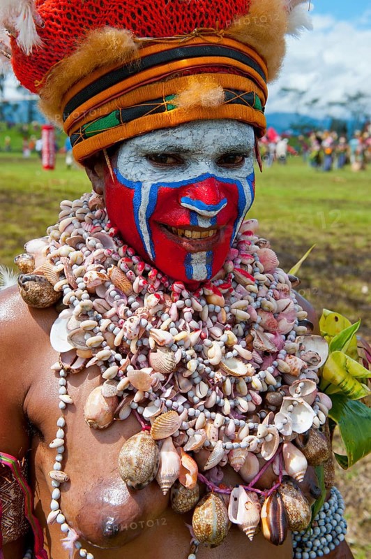 Woman in a colourfully decorated costume with face paint at the traditional sing-sing gathering