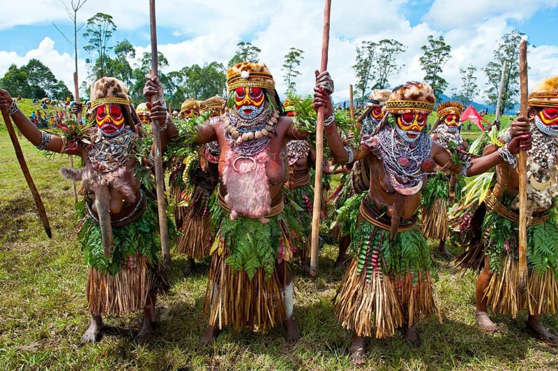 Members of a tribe in colourfully decorated costumes with face paint at the traditional sing-sing gathering