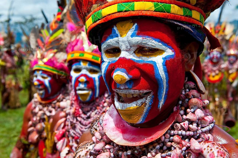 Members of a tribe in colourfully decorated costumes with face paint at the traditional sing-sing gathering