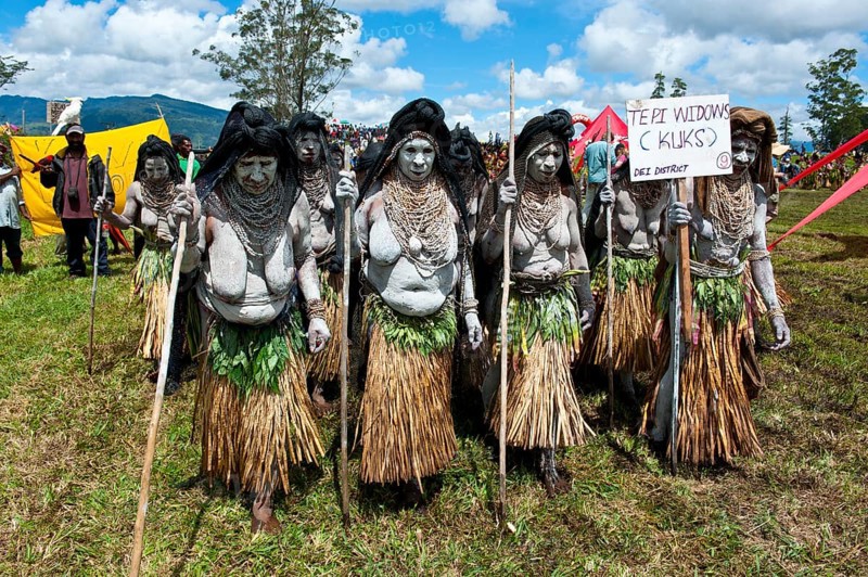 Women in colourfully decorated costumes with face and body paint at the traditional sing-sing gathering