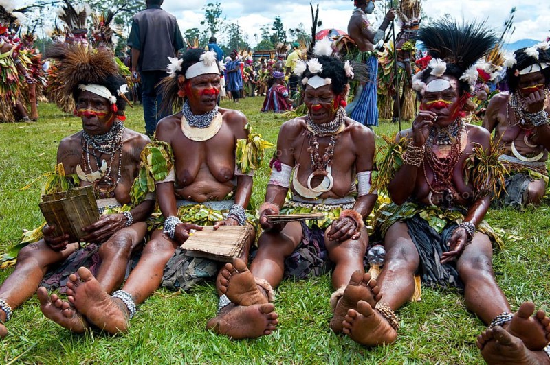 Women in colourfully decorated costumes with face paint at the traditional sing-sing gathering