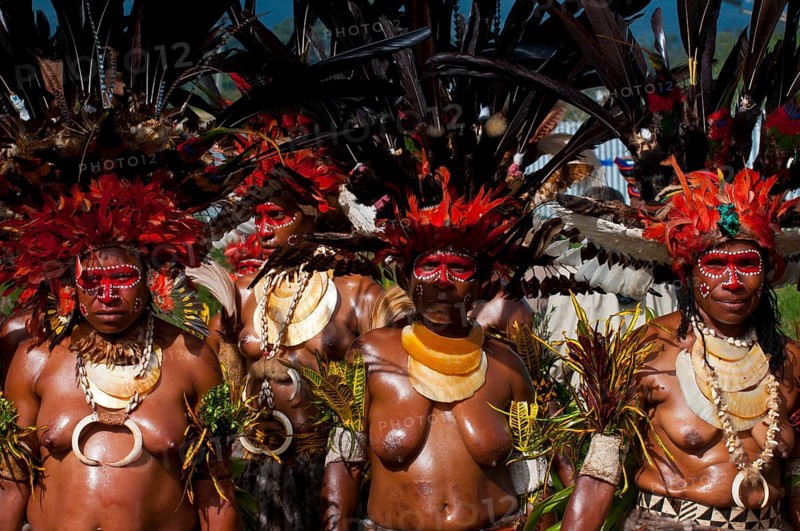 Women in colourfully decorated costumes with face paint at the traditional sing-sing gathering