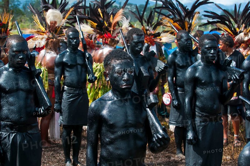 Members of a tribe covered in black paint at the traditional sing-sing gathering